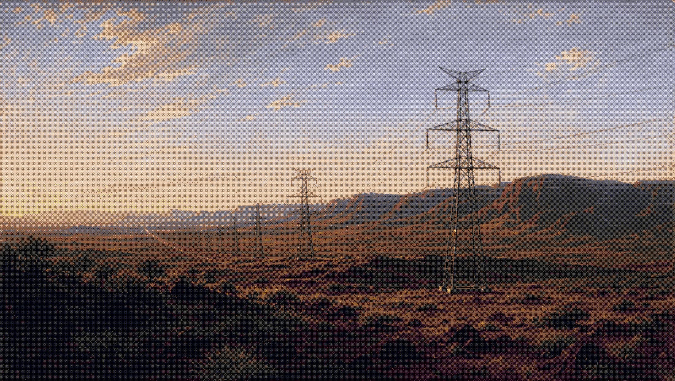 transmission towers stepping across the pilbara under a wide sky